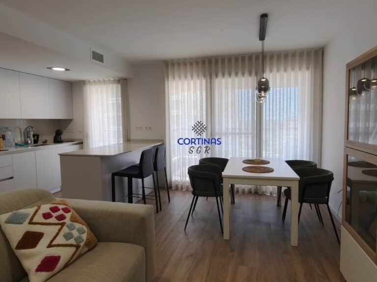 Instalación de cortinas de onda perfecta en salón comedor con cocina abierta